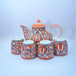 Load image into Gallery viewer, Floral Charm Tea Set by Tanutra - Hand-painted ceramic teapot and cups with vibrant orange and white floral motifs, perfect for tea rituals, home decor, and gifting. Authentic Indian craftsmanship.
